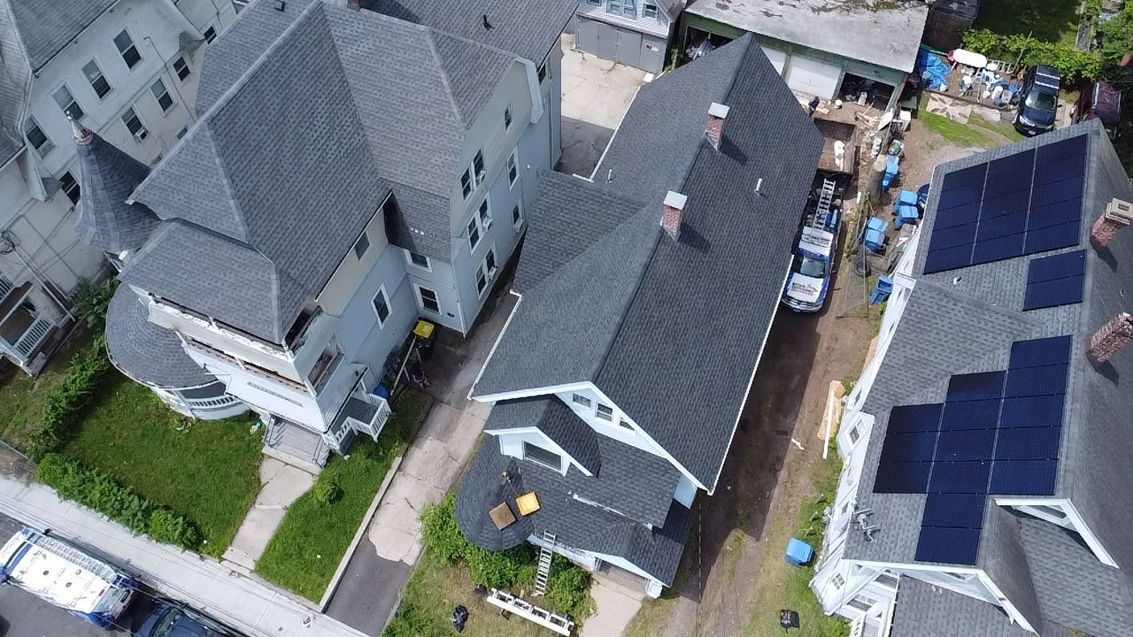 Aerial drone view of a Connecticut home’s roof with solar panel integration, completed by Ecua Giovanny Construction
