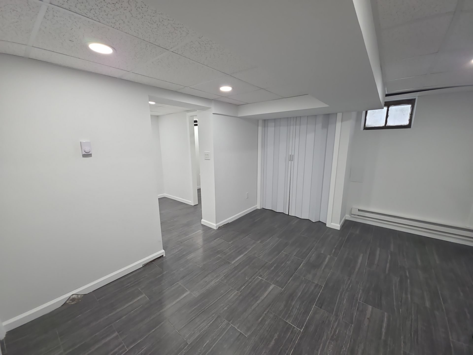 A finished basement with dark flooring